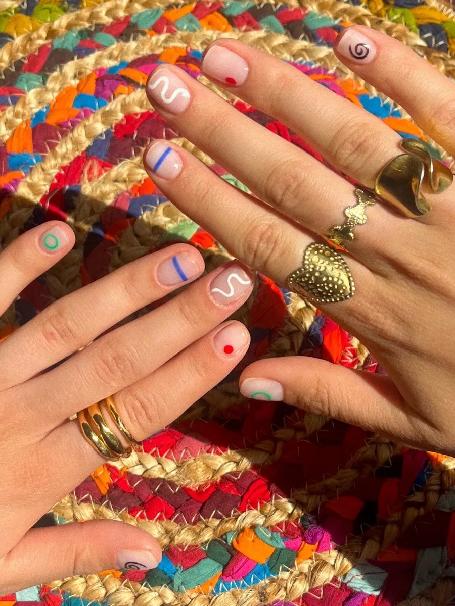Nail art minimaliste coloré : traits, cœur et pois sur ongles nude